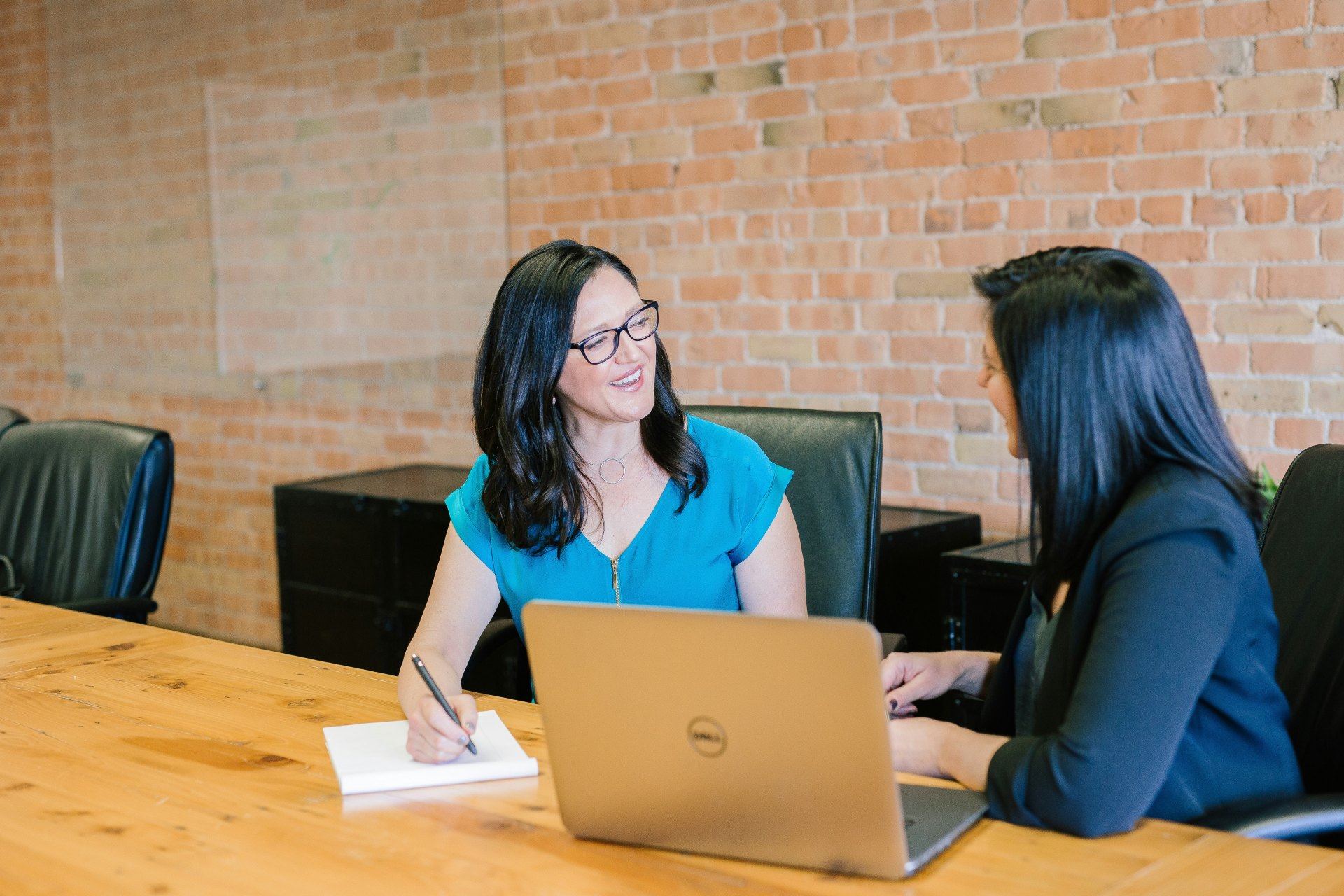 2 professional ladies discussing and working on laptop