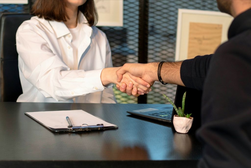 Handshake over a desk, signifying a business agreement.